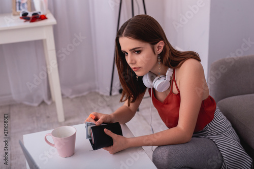 From fathers wallet. Attentive teen girl stealing money while carrying wallet