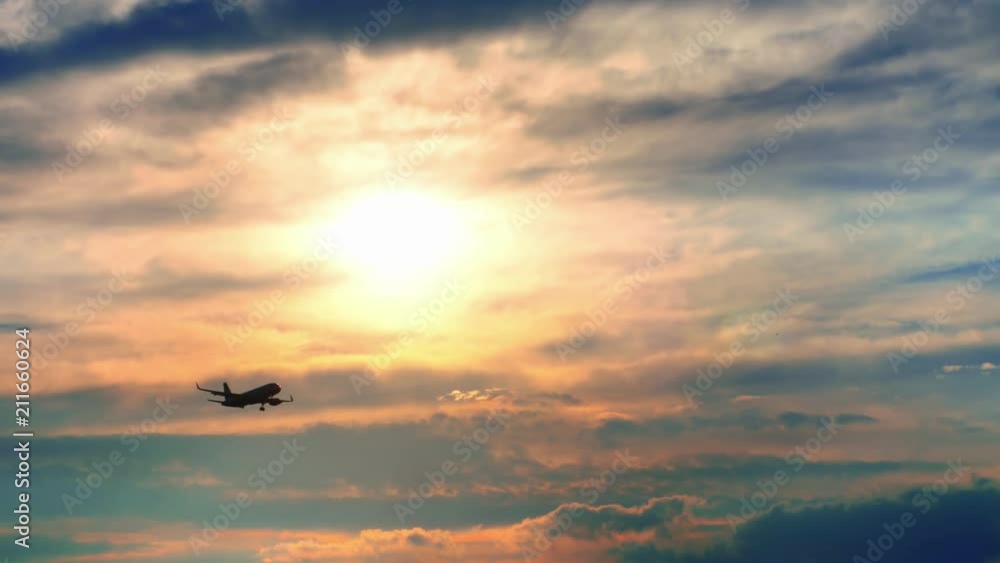 The plane flies against the background of the sunrise