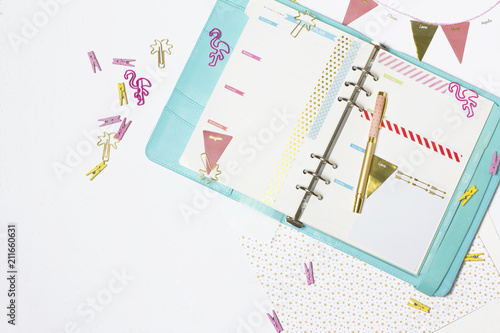 Feminine stationery: colorful paper binder clips palm and flamingo shape on white table background with washi tape. Flat lay