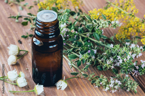 A bottle of dark glass with essential oil of thyme for aromatherapy and health. photo