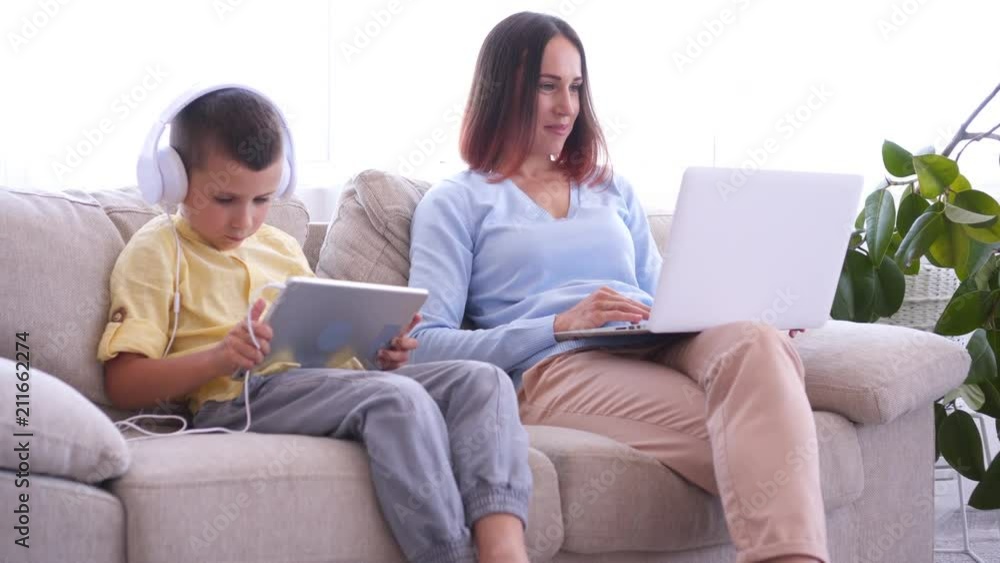Mother and son spending time using gadgets Mother and son spending time using gadgets