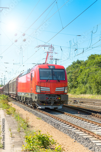 Güterzug mit einer modernen Lokomotive mit Sonne