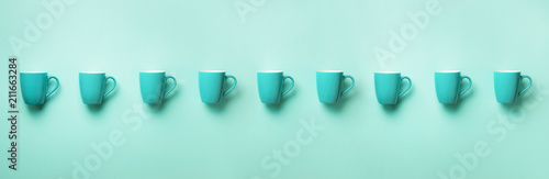 Pattern from blue cups over blue background. Banner. Birthday party celebration, baby shower concept. Punchy pastel colors. Minimalist style design