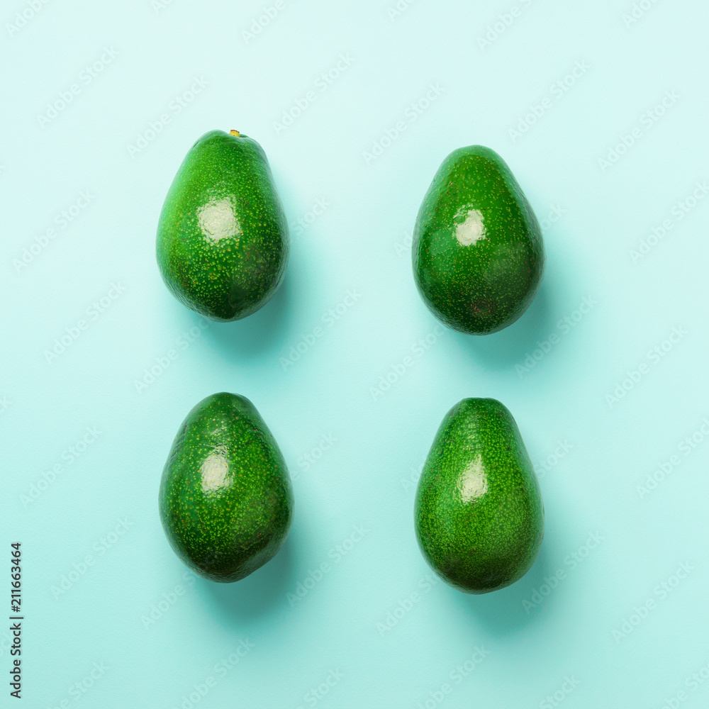Green avocado pattern on blue background. Top view. Pop art design, creative summer food concept. Organic avocadoes in minimal flat lay style. Square crop Green avocado pattern on blue background. Top view. Pop art design, creative summer food concept. Organic avocadoes in minimal flat lay style. Square crop