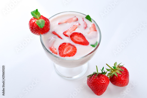 Homemade yogurt with fresh red strawberry on a wooden background. Top view.