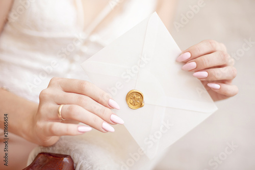 close-up woman with slim body holding invitation envelope card in hands, rear veaw.