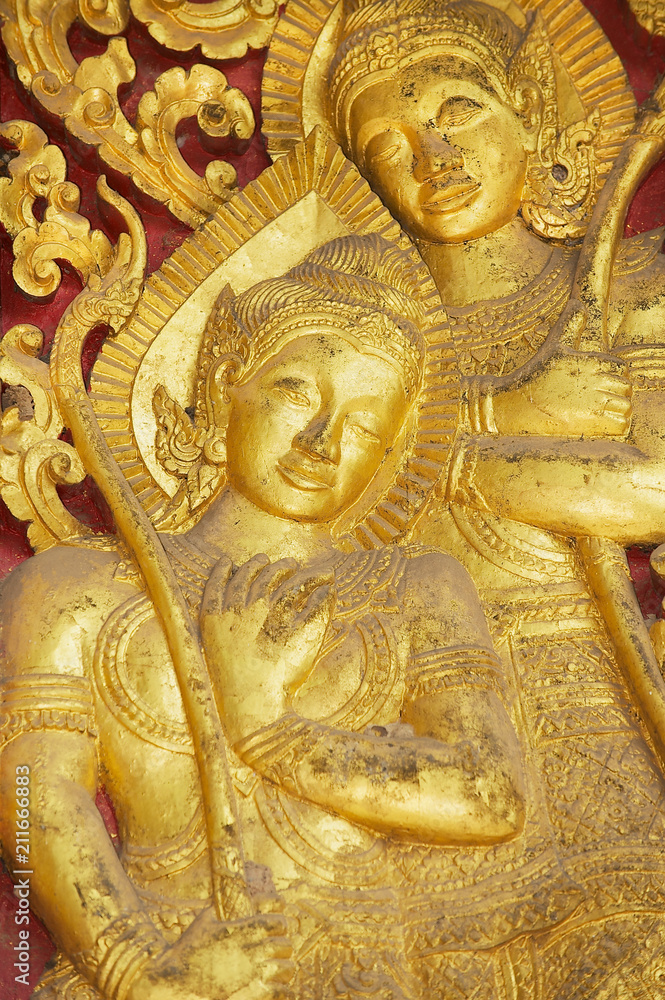 Detail of the ancient golden exterior wall decoration at Wat Xieng Thong Buddhist temple in Luang Prabang, Laos.