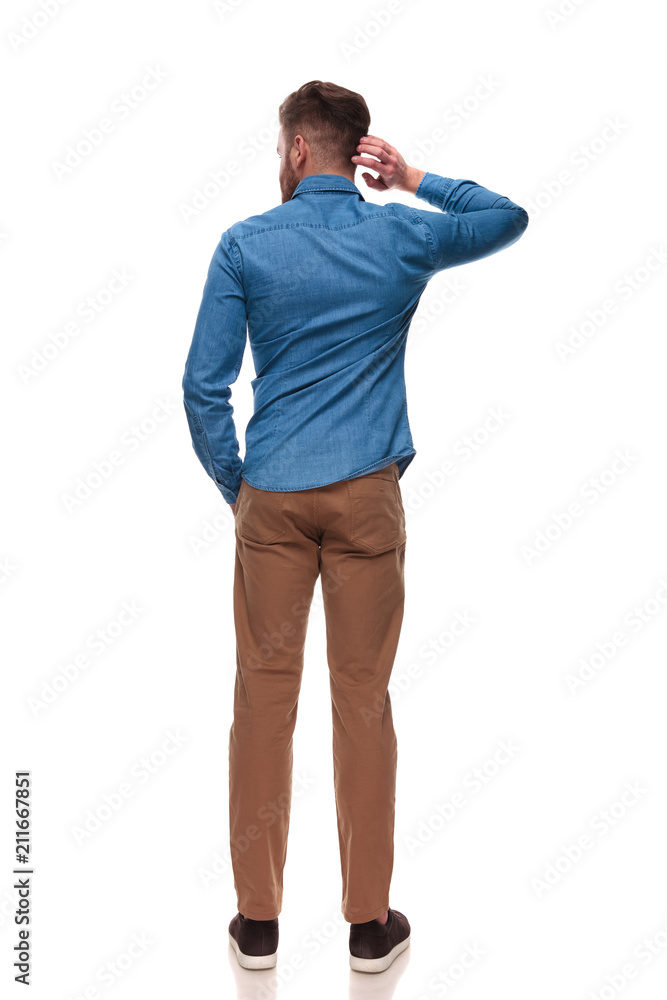 back view of relaxed casual man scratching his head back view of relaxed casual man scratching his head