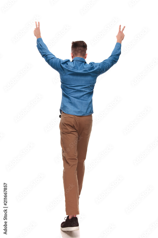 back view of stepping casual man making peace sign back view of stepping casual man making peace sign