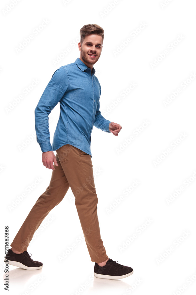 attractive young casual man walks to side attractive young casual man walks to side