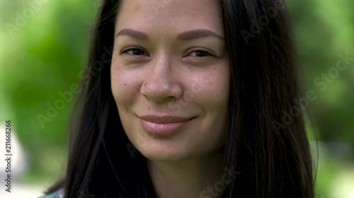 A portrait of a cute asian woman blinking with her eyes. Close-up.
