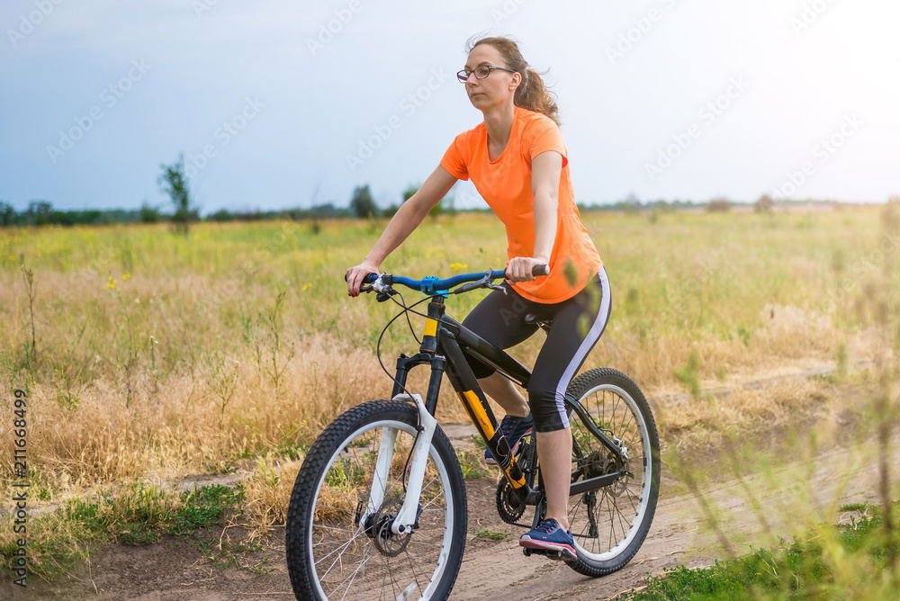 Woman is riding a bicycle, an active lifestyle.