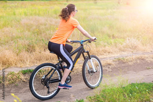 Woman is riding a bicycle, an active lifestyle.