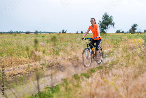 Woman is riding a bicycle, an active lifestyle.