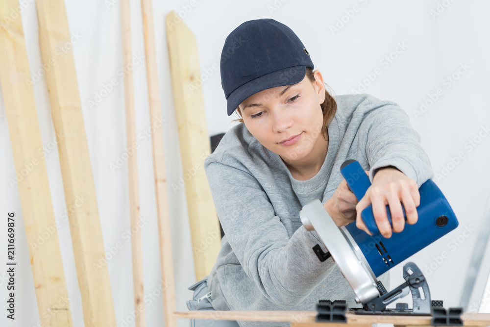 female carpenter is using a circular saw female carpenter is using a circular saw