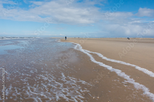 Fototapeta Naklejka Na Ścianę i Meble -  Nordsee endloser Strand mit Wellen und Spaziergängern