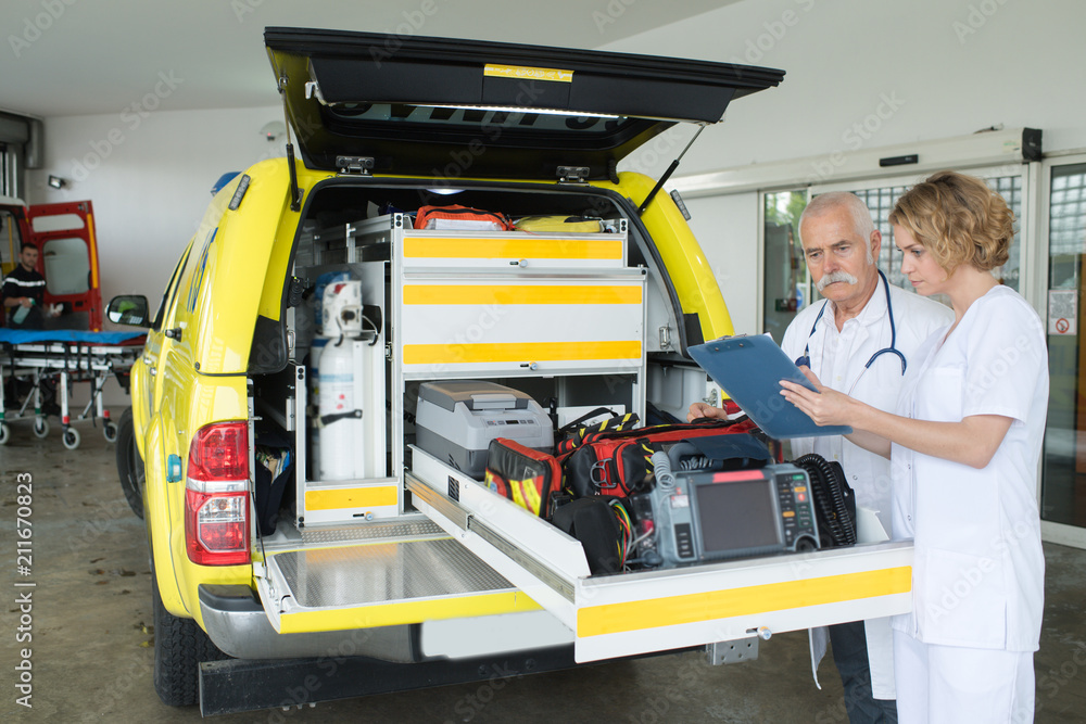 female and male doctor preparing an ambulance female and male doctor preparing an ambulance