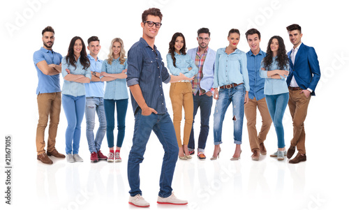 young casual man presenting his team standing behind