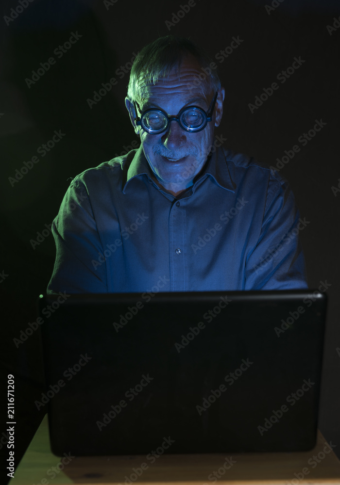 Mature man looking at a computer screen with a humorous look Mature man looking at a computer screen with a humorous look