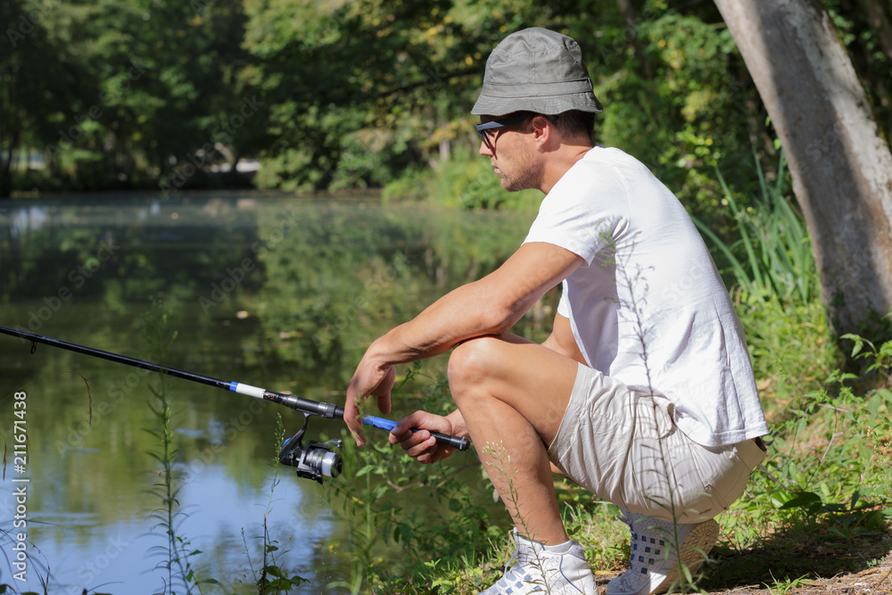 fisher man fishing at lakeside fisher man fishing at lakeside