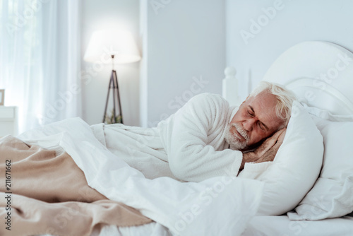 Good night. Tranquil senior man lying in bed and napping