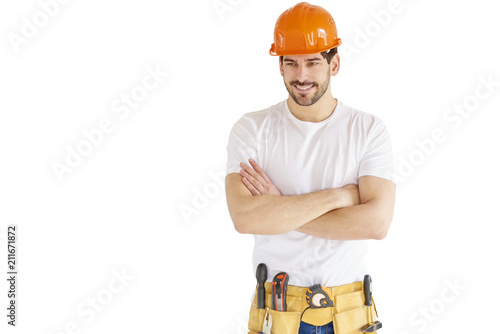 Handyman portrait. Young construction worker wearing hard hat and tool belt against white isolated background photo