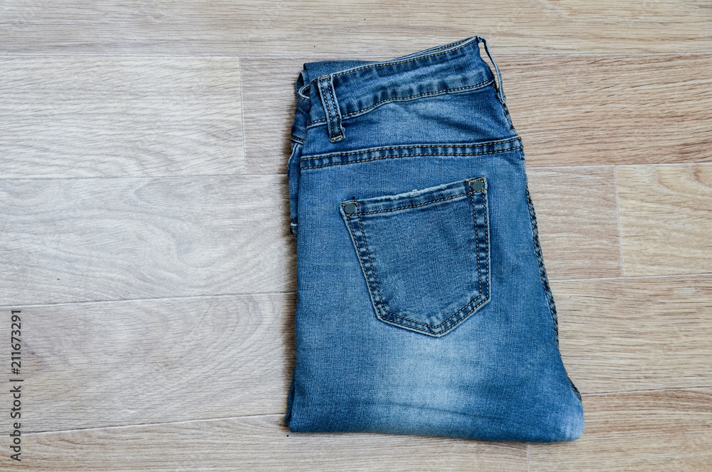 jeans on the background, blue jeans lie on a wooden background, jeans on the background, blue jeans lie on a wooden background,