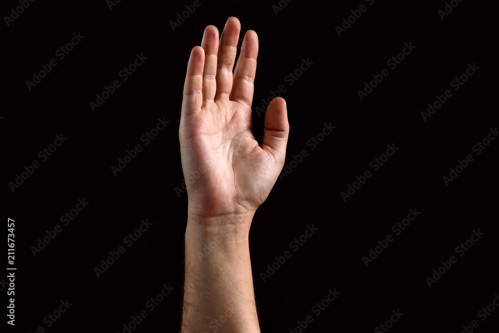 Male palm raised up, isolated on a dark background. Isolate Male palm raised up, isolated on a dark background. Isolate
