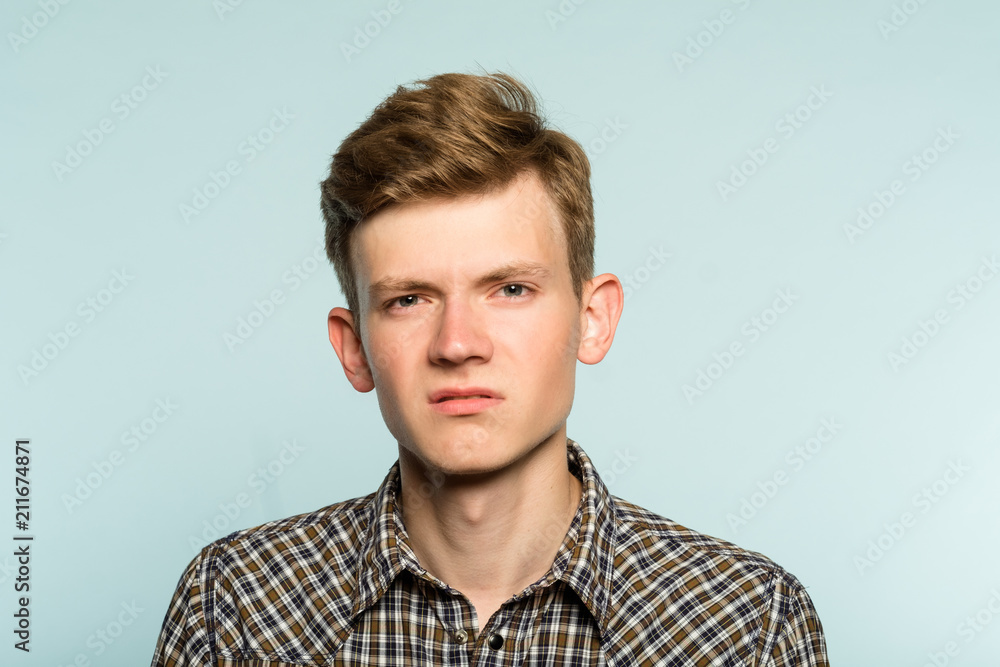 man with a scornful disdainful disrespectful look. portrait of a young guy on light background. emotion facial expression. feelings and people reaction concept. man with a scornful disdainful disrespectful look. portrait of a young guy on light background. emotion facial expression. feelings and people reaction concept.