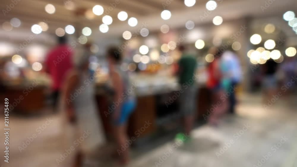 Visitors in the restaurant are out of focus. Defocused image of people, bokeh, lights inside the buffet restaurant. Visitors in the restaurant are out of focus. Defocused image of people, bokeh, lights inside the buffet restaurant.