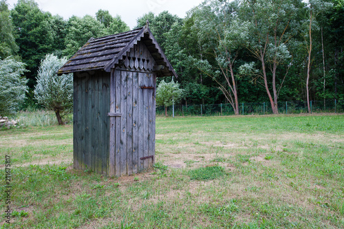 Rustic wooden toilet on the street in the background of trees © Lidia_Lo