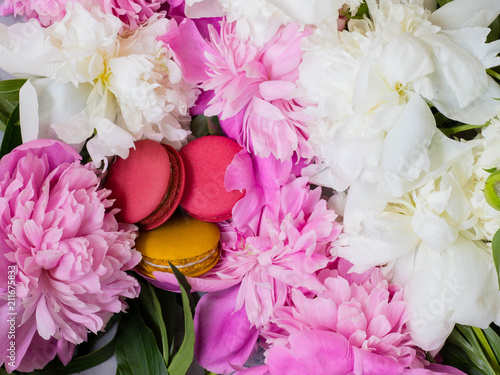 pink and yellow macaroons on peony background. Pink and white peony and macaroons. photo