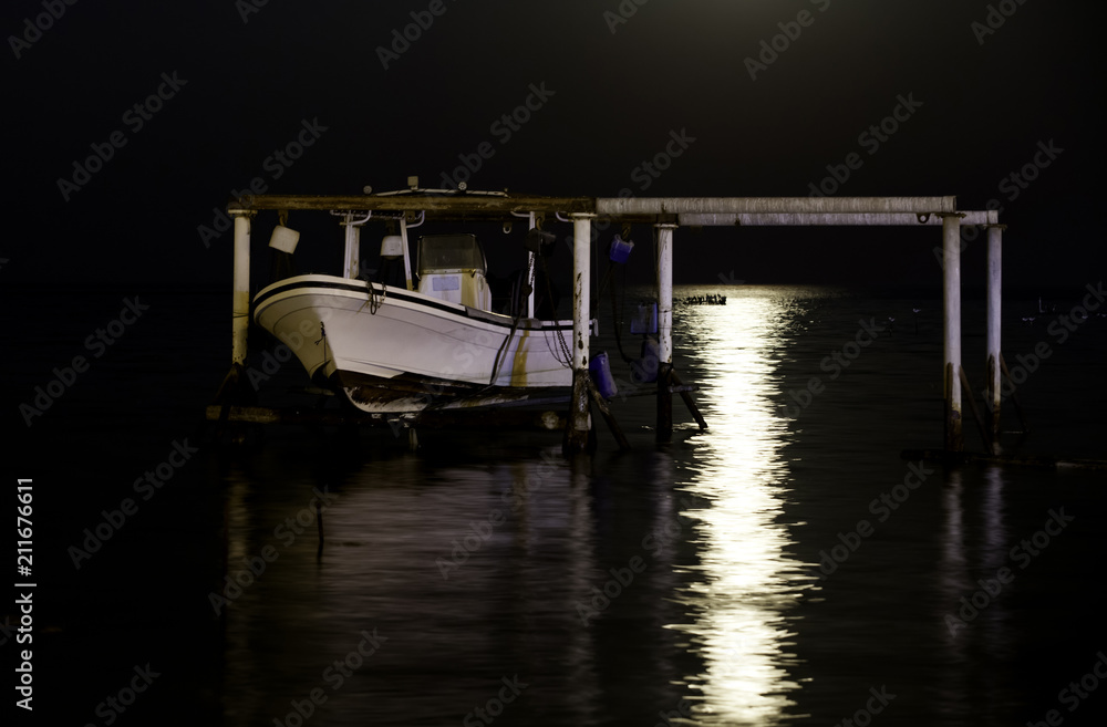 Reflection of Supermoon and a boat at Asker coast of Bahrain on 14 November 2016