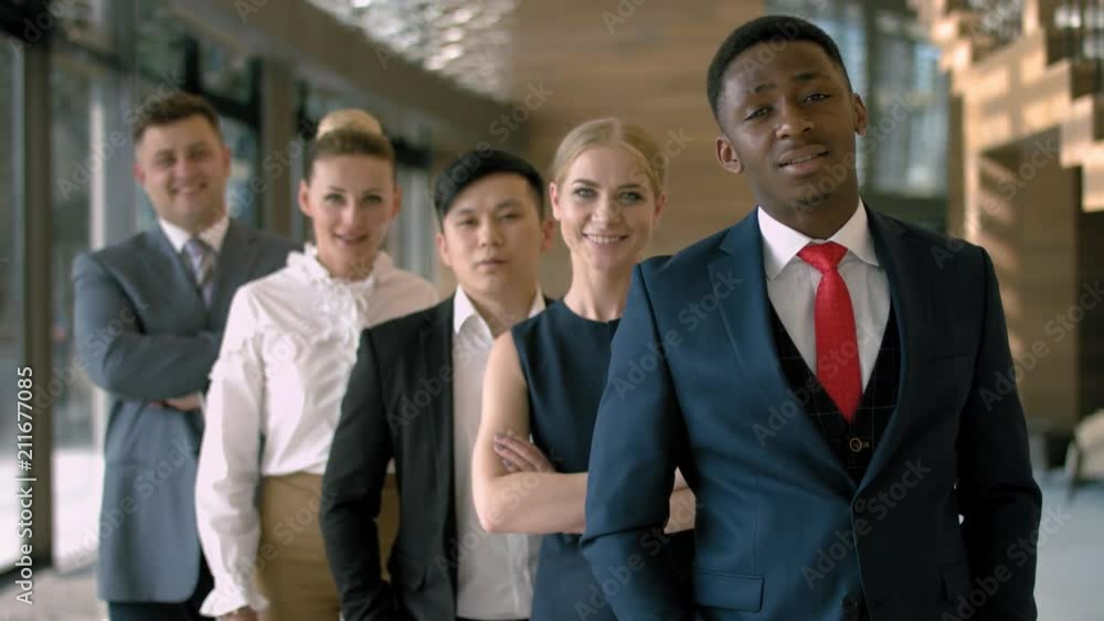 Portrait of handsome black business man with four employees in the business hall Portrait of handsome black business man with four employees in the business hall