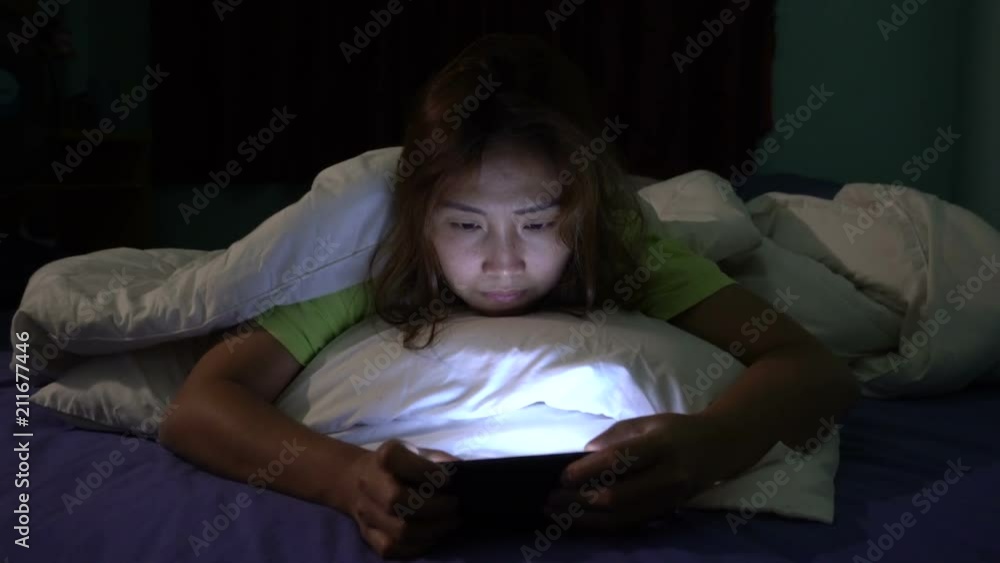 Asian woman play smartphone in the bed at night,Thailand people,Addict social media,Play internet all night Asian woman play smartphone in the bed at night,Thailand people,Addict social media,Play internet all night