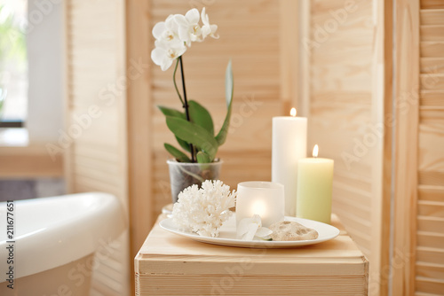 set for spa procedure with towel for bathroom procedures, burning candles and flowers.