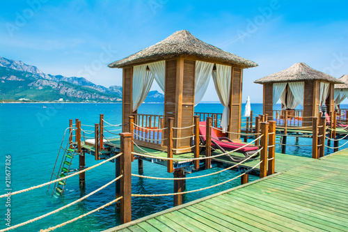 Wooden beach pavilions on the shore of a sandy beach