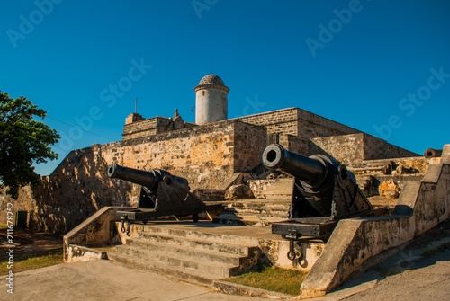 Old weathered cannons and shots exposition near the walls of Jagua fortress Fortaleza de Jagua. Cienfuegos, Cuba. photo