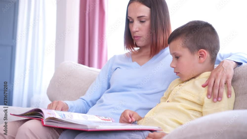 Caring mom and son reading book together Caring mom and son reading book together