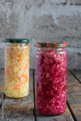 Sauerkraut in glass jar, marinated cabbage, carrot and beetroot. Probiotic and fermented food. Pickles. Canned vegetarian food concept.