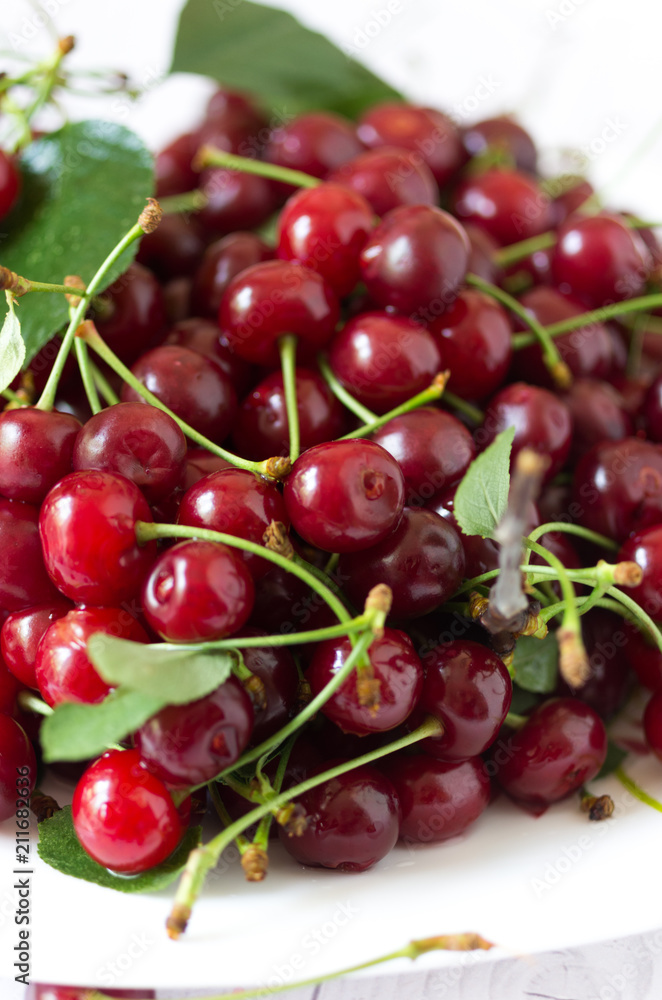 Cherries in a plate. Fresh cherries and leaves.