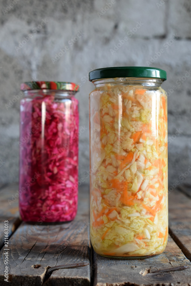 Sauerkraut in glass jar, marinated cabbage, carrot and beetroot. Probiotic and fermented food. Pickles. Canned vegetarian food concept. Sauerkraut in glass jar, marinated cabbage, carrot and beetroot. Probiotic and fermented food. Pickles. Canned vegetarian food concept.