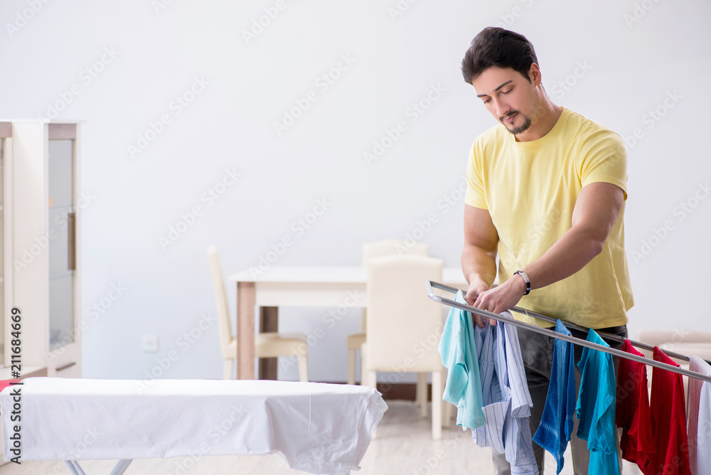 Handsome man husband doing laundering at home Handsome man husband doing laundering at home
