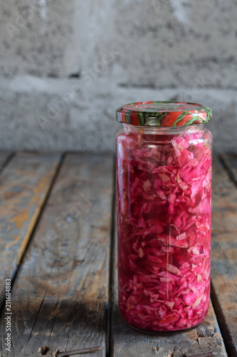 Sauerkraut in glass jar, marinated cabbage, carrot and beetroot. Probiotic and fermented food. Pickles. Canned vegetarian food concept.