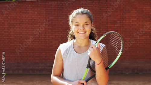 Portrait of pretty young tennis playgirl standing with racket. photo