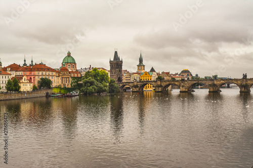 Charles Bridge in Prague summer day and the sky with clouds. Medieval bridge over the Vltava River, which connects historic districts Lesser and Stare Mesto