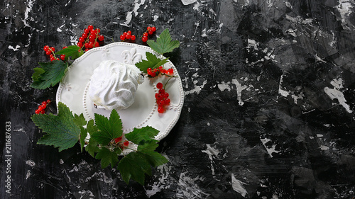 Meringue desert with red berries on plate on dark background. Top view. Free copy space photo