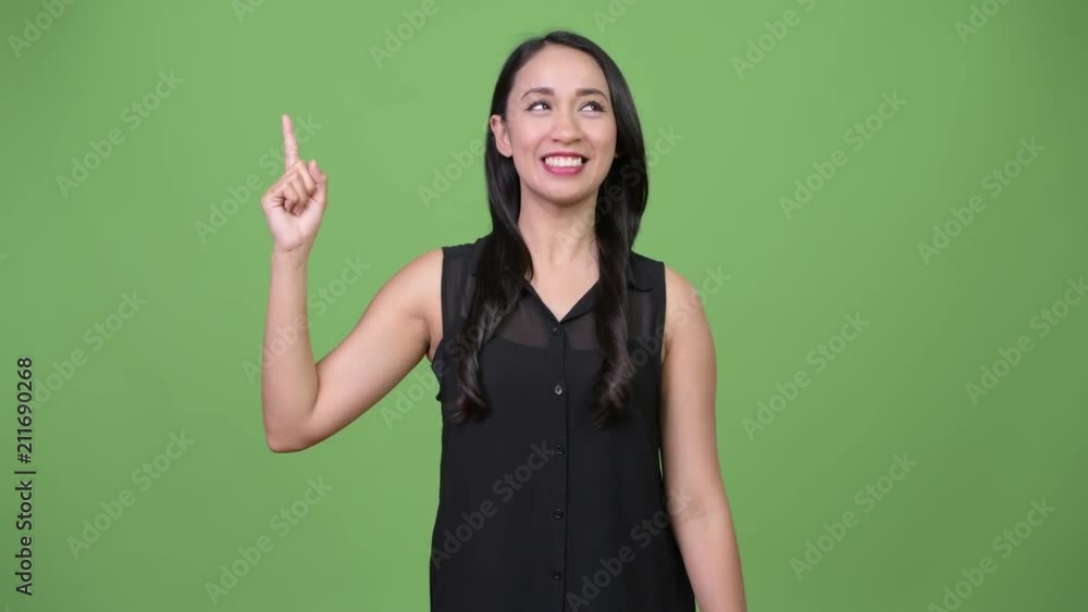 Young beautiful Asian businesswoman pointing finger up Young beautiful Asian businesswoman pointing finger up