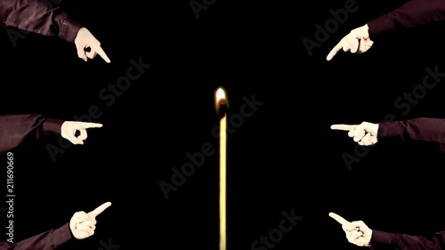 Many hands pointing at a tiny match starting to burn without anyone igniting it.
