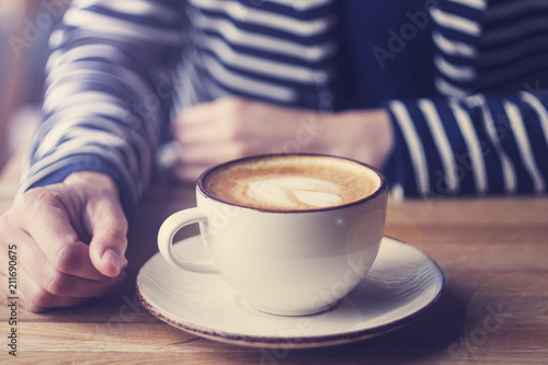 Girl having a break with cup of coffee, close up, soft focus, vintage filter.